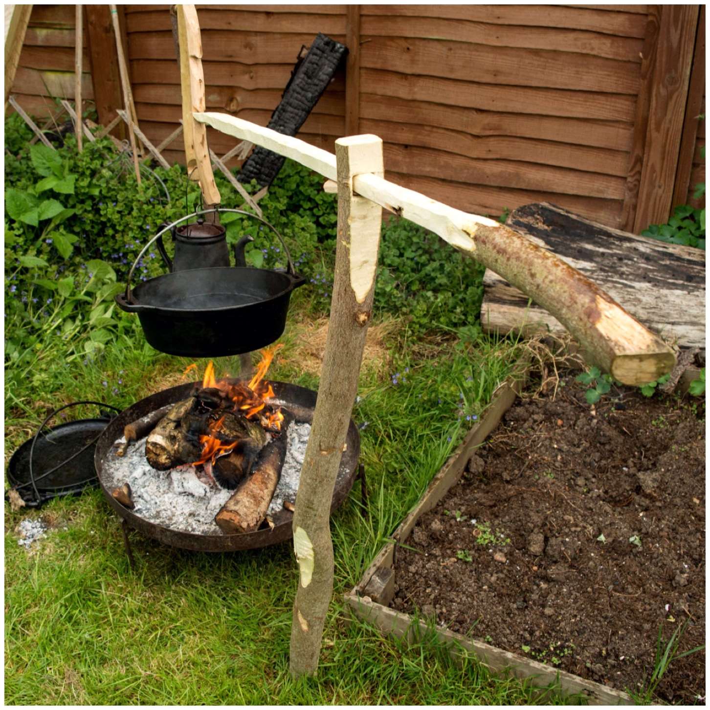 Outdoor cooking, swinging arm cast iron pot hanger